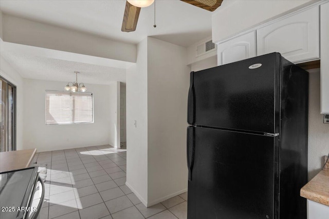 kitchen featuring visible vents, range with electric cooktop, white cabinetry, freestanding refrigerator, and light tile patterned floors