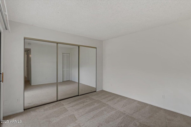 unfurnished bedroom featuring a closet, carpet flooring, and a textured ceiling