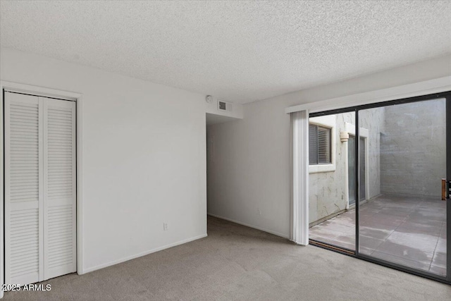 unfurnished bedroom featuring a closet, carpet, and a textured ceiling