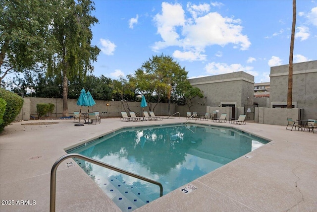 pool with a patio and fence