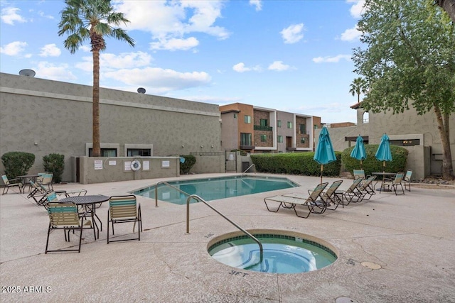 pool featuring a hot tub, a patio, and fence