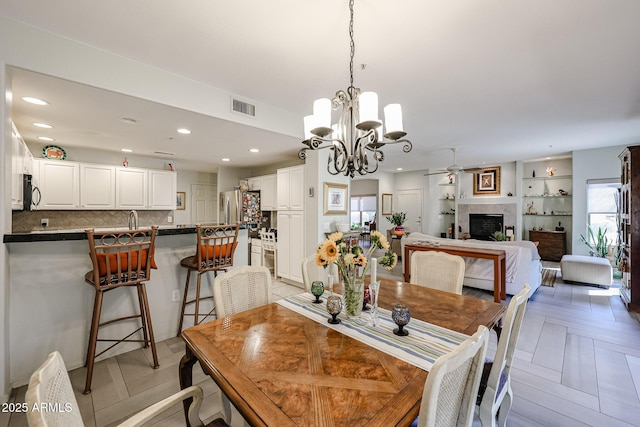 19700 N 76th St Unit 1124, Scottsdale, AZ 85255 - dining area with recessed lighting, ceiling fan with notable chandelier, a fireplace, and visible vents