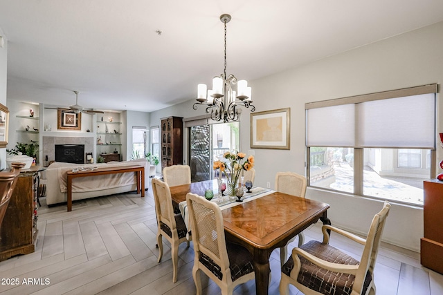 19700 N 76th St Unit 1124, Scottsdale, AZ 85255 - dining space featuring a wealth of natural light, a tile fireplace, built in shelves, and ceiling fan with notable chandelier