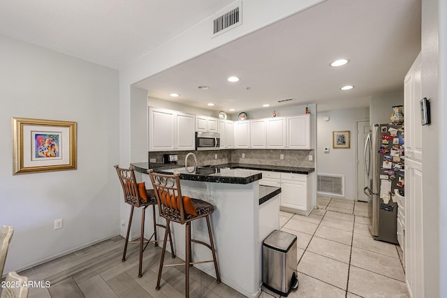 19700 N 76th St Unit 1124, Scottsdale, AZ 85255 - kitchen featuring visible vents, a peninsula, a kitchen breakfast bar, and stainless steel appliances