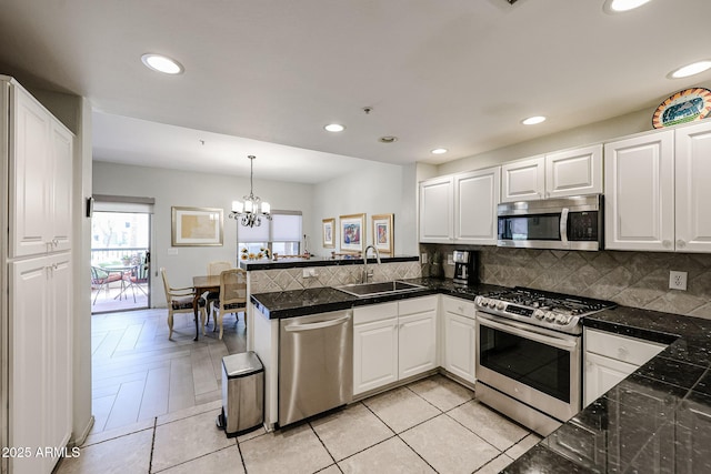 19700 N 76th St Unit 1124, Scottsdale, AZ 85255 - kitchen featuring white cabinetry, stainless steel appliances, backsplash, a sink, and a peninsula