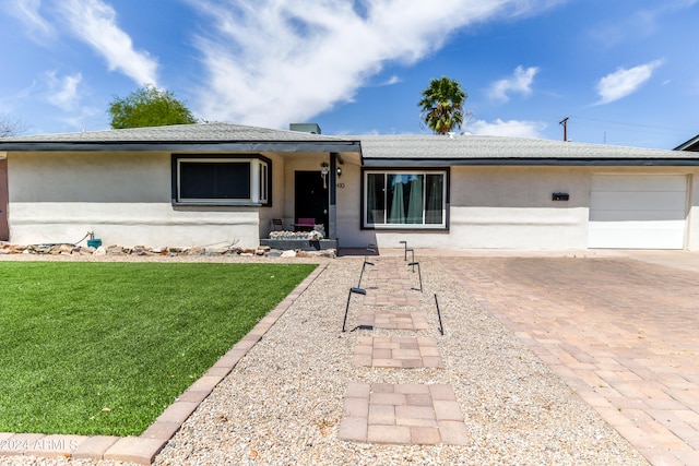 single story home featuring a front yard and a garage