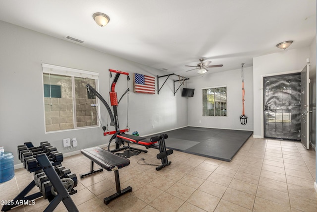 workout area featuring ceiling fan and light tile patterned floors