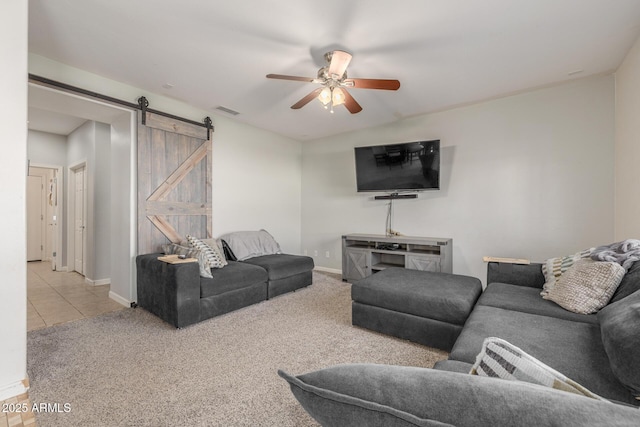 living room featuring light carpet, a barn door, and ceiling fan