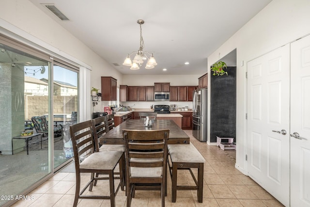 dining space with light tile patterned flooring and a notable chandelier