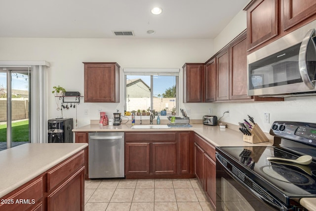 kitchen featuring sink, light tile patterned floors, and stainless steel appliances