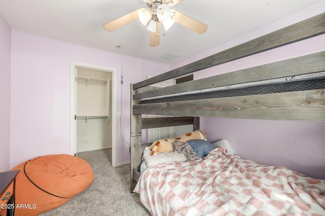 bedroom with ceiling fan, light colored carpet, a spacious closet, and a closet