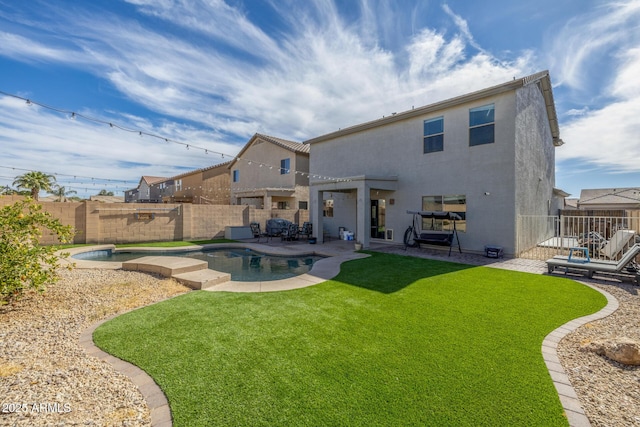 rear view of property featuring a pool with hot tub, a patio, and a lawn