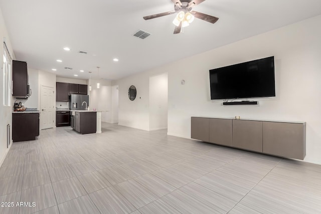 unfurnished living room with ceiling fan, visible vents, and recessed lighting