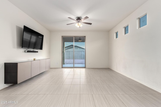 unfurnished living room with ceiling fan and baseboards