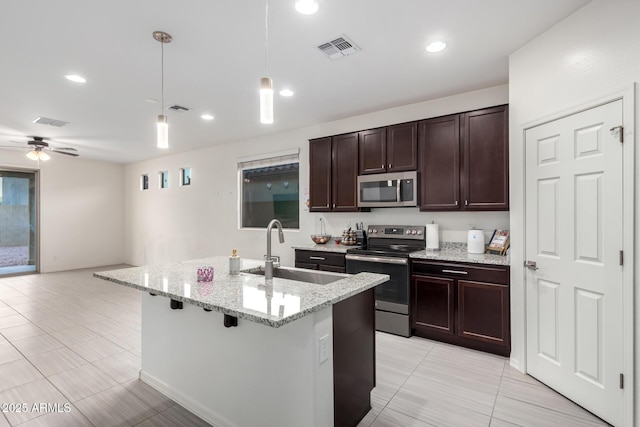 kitchen featuring dark brown cabinetry, visible vents, appliances with stainless steel finishes, pendant lighting, and a sink