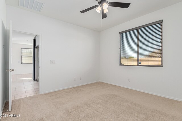 carpeted spare room with ceiling fan and a healthy amount of sunlight