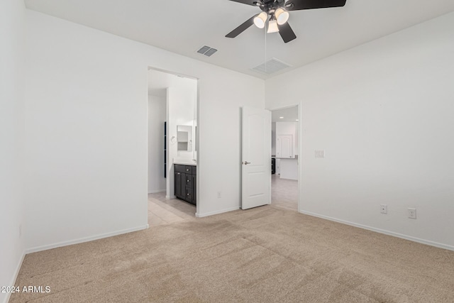 spare room with ceiling fan and light carpet