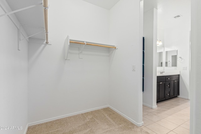 walk in closet featuring light tile patterned floors and sink