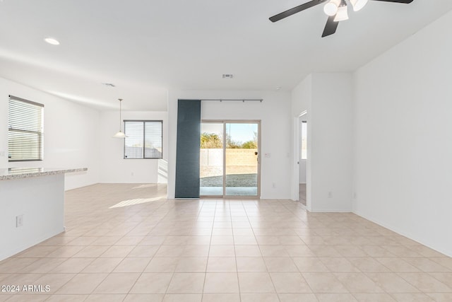 tiled spare room featuring ceiling fan