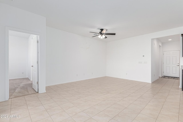 empty room featuring ceiling fan and light colored carpet