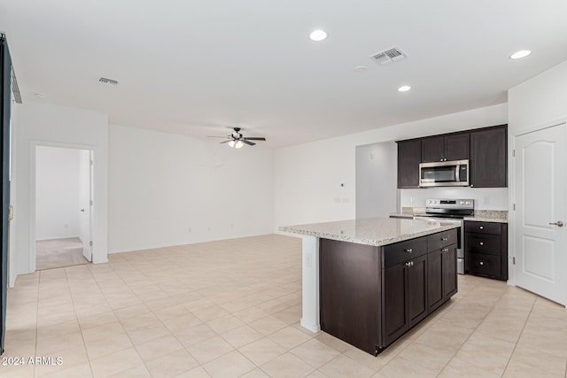 kitchen featuring ceiling fan, a center island, dark brown cabinetry, and stainless steel appliances