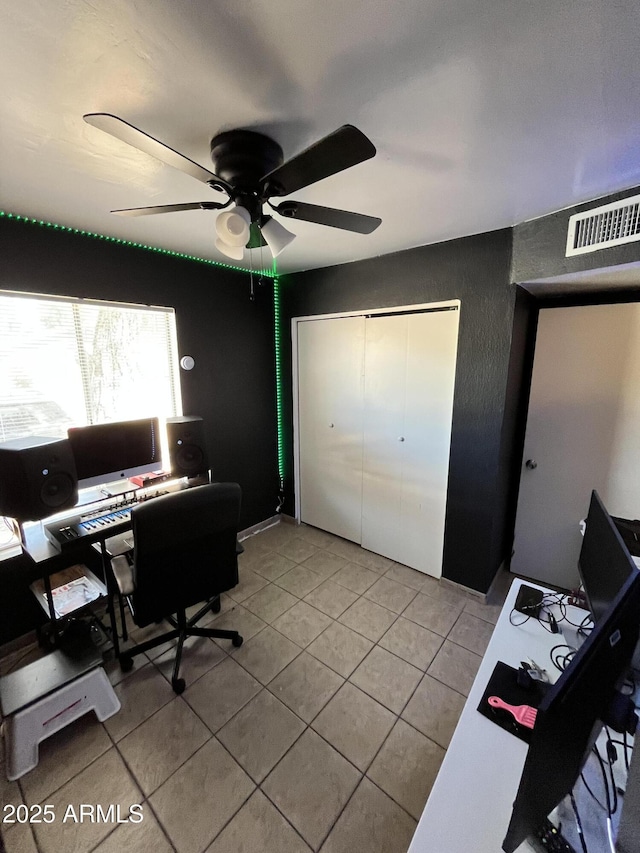 office space with light tile patterned floors and a ceiling fan