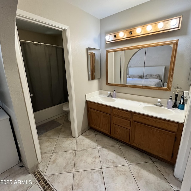 ensuite bathroom featuring double vanity, toilet, tile patterned floors, and curtained shower