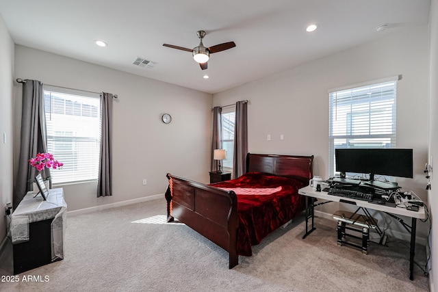 bedroom with multiple windows, light colored carpet, and ceiling fan