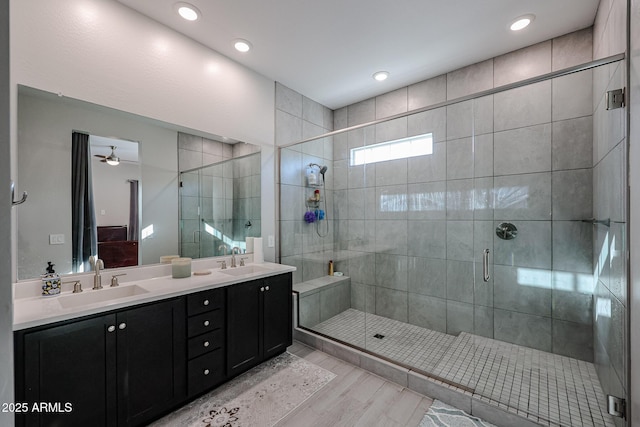 bathroom with vanity, hardwood / wood-style flooring, a shower with door, and ceiling fan