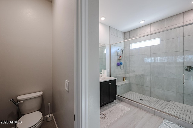 bathroom featuring vanity, toilet, and a shower with door