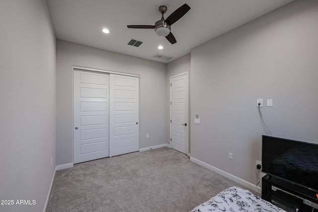 unfurnished bedroom with light colored carpet, ceiling fan, and a closet