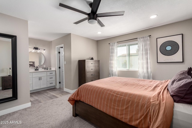 carpeted bedroom with sink, ceiling fan, and ensuite bathroom