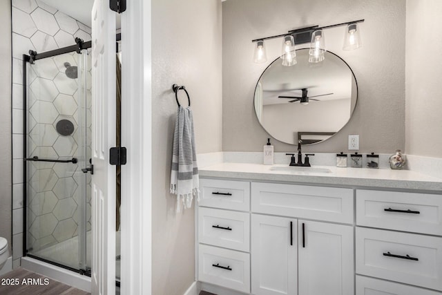 bathroom featuring a shower with door and vanity