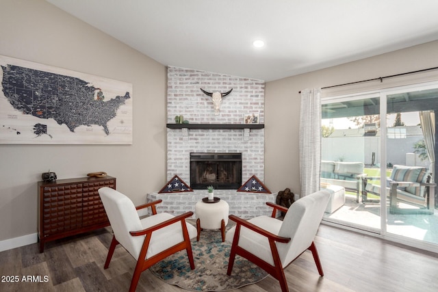 living room with lofted ceiling, hardwood / wood-style flooring, and a fireplace