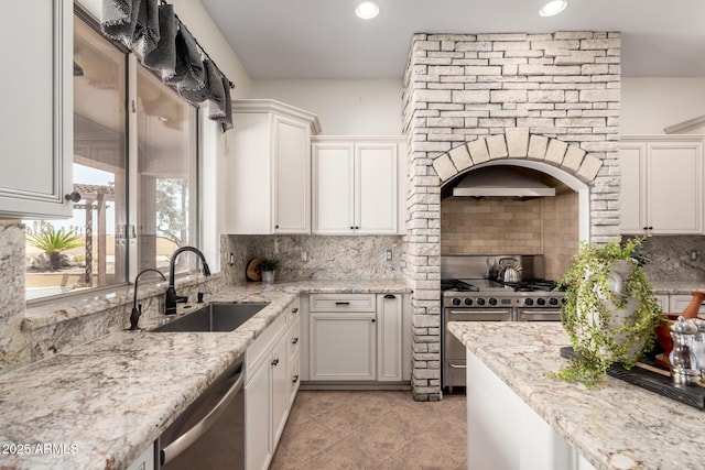 kitchen featuring a sink, backsplash, white cabinetry, and stainless steel appliances