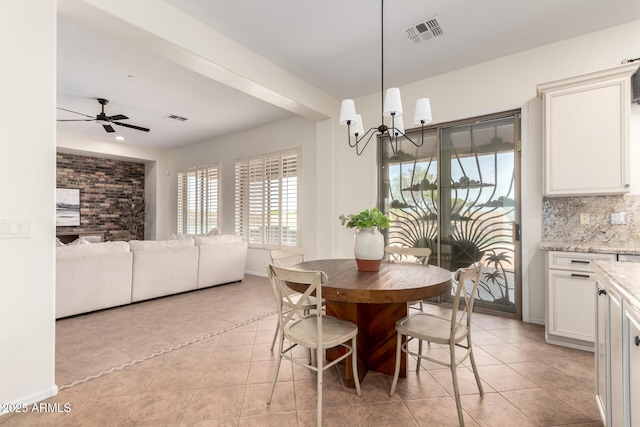 dining space with ceiling fan with notable chandelier, light tile patterned floors, and visible vents