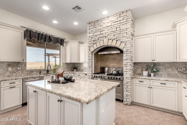 kitchen featuring tasteful backsplash, appliances with stainless steel finishes, visible vents, and a kitchen island