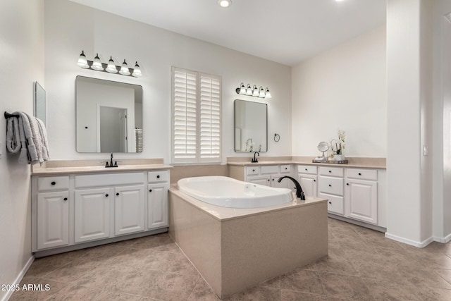 full bathroom with a garden tub, two vanities, a sink, and tile patterned flooring