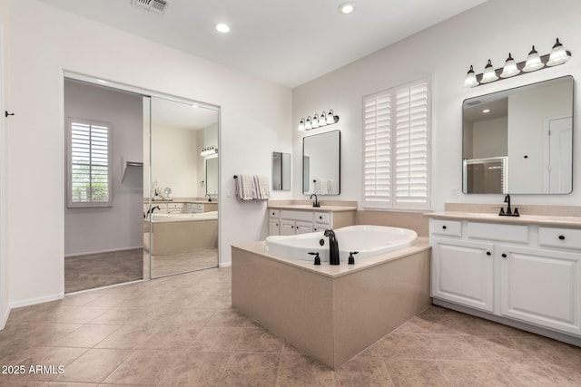 bathroom with baseboards, a sink, recessed lighting, tile patterned floors, and a garden tub