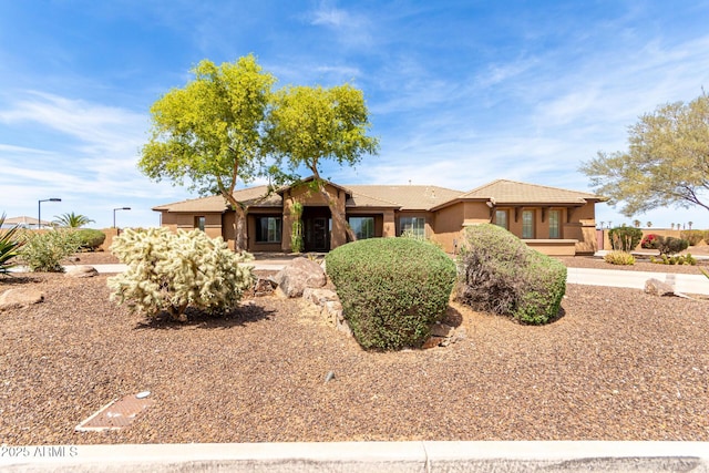 ranch-style house with a tile roof and stucco siding