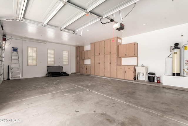 garage featuring a sink, gas water heater, and a garage door opener