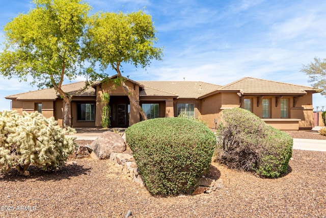 single story home featuring stucco siding and a tile roof