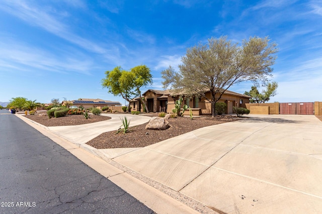 view of front of house featuring curved driveway, fence, and stucco siding