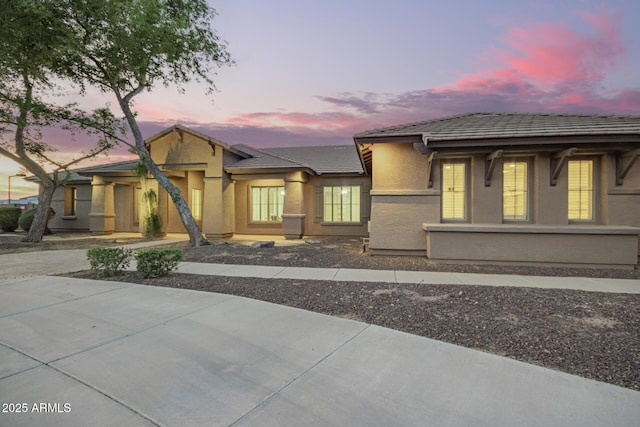 prairie-style house featuring stucco siding and a tile roof