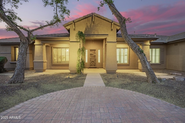 view of front facade featuring stucco siding and a tile roof