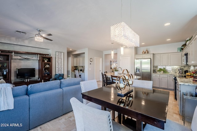 dining room with ceiling fan with notable chandelier