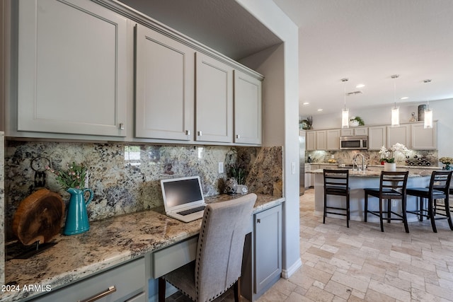 kitchen with gray cabinets, a breakfast bar, and built in desk