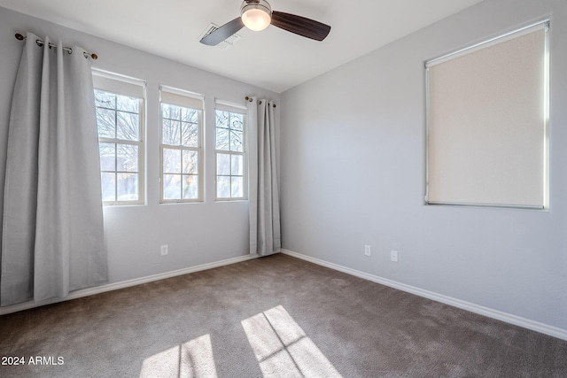 carpeted spare room featuring ceiling fan