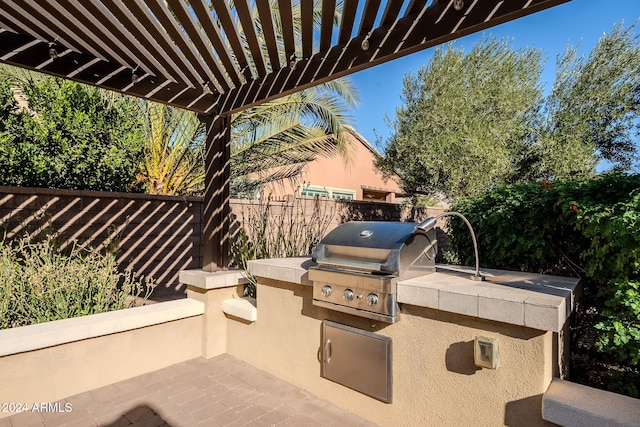 view of patio / terrace featuring area for grilling, a grill, and a pergola