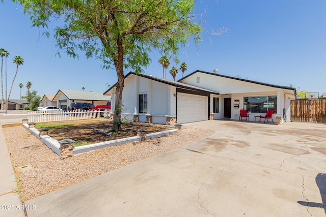 ranch-style house with fence, an attached garage, and concrete driveway